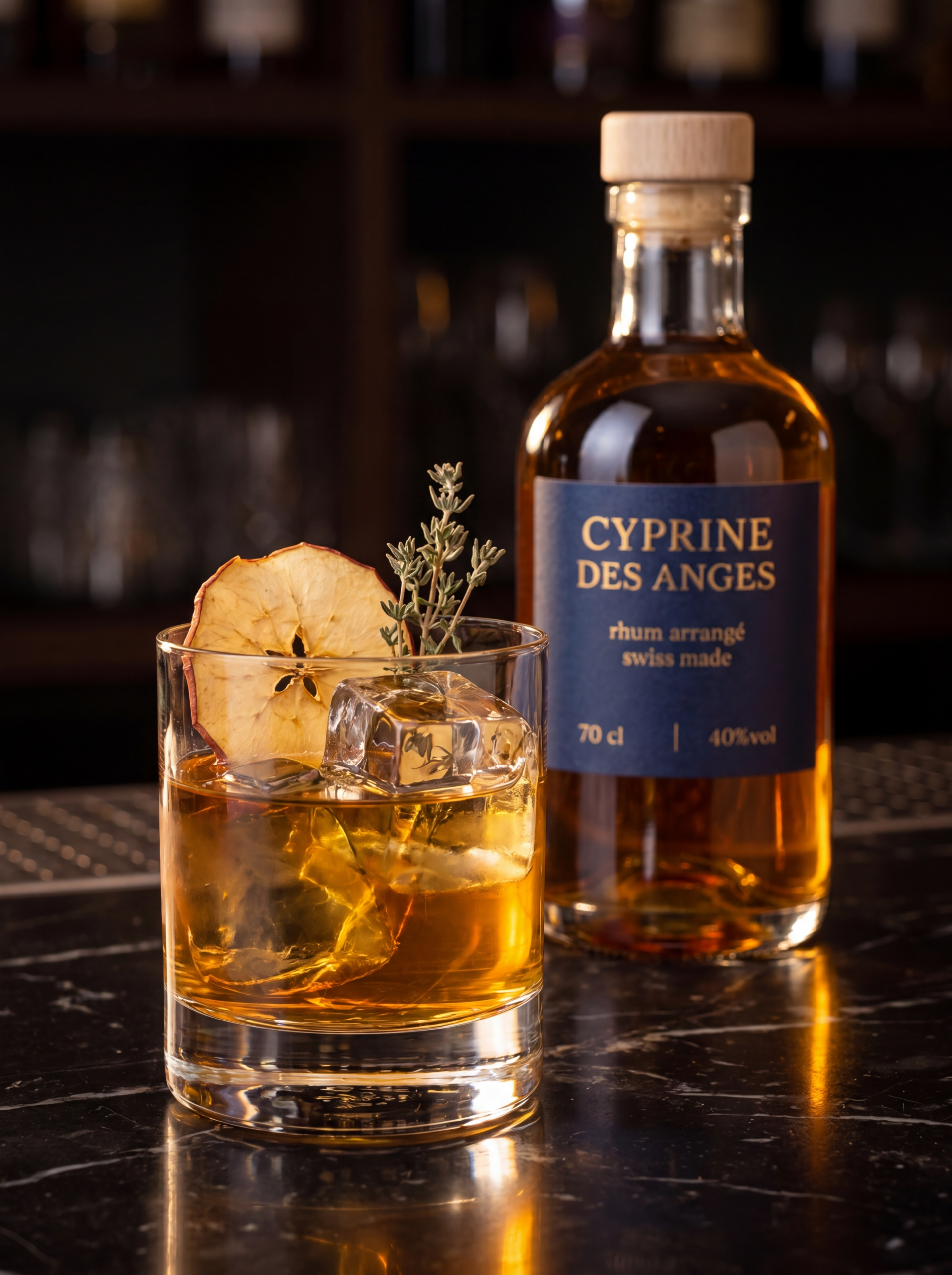 Cocktail à base de Cyprine des Anges avec pomme séchée, glaçons et bouteille en arrière-plan